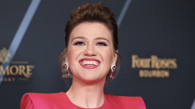 Kelly Clarkson posing for reporters at an event