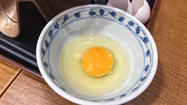 raw egg sitting inside a bowl