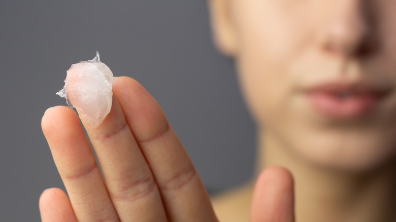 Woman with petroleum jelly on her fingertip