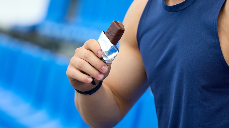 Man holding a chocolate protein bar