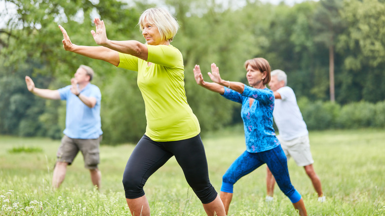 Group of people doing tai chi outdoors