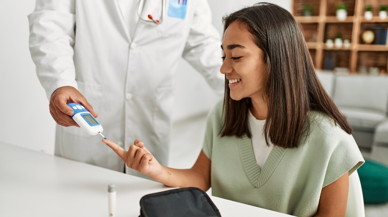 woman having blood sugar drawn by doctor