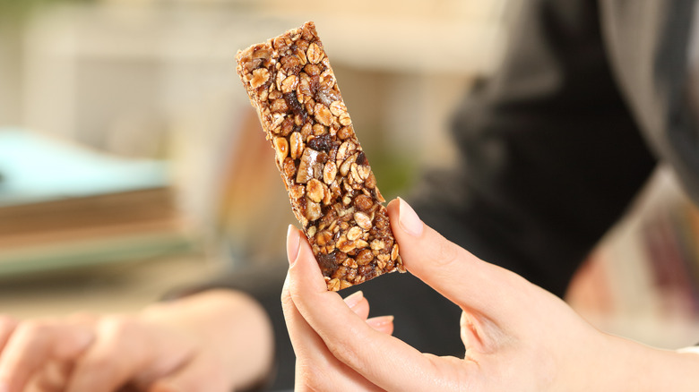 woman holding granola bar