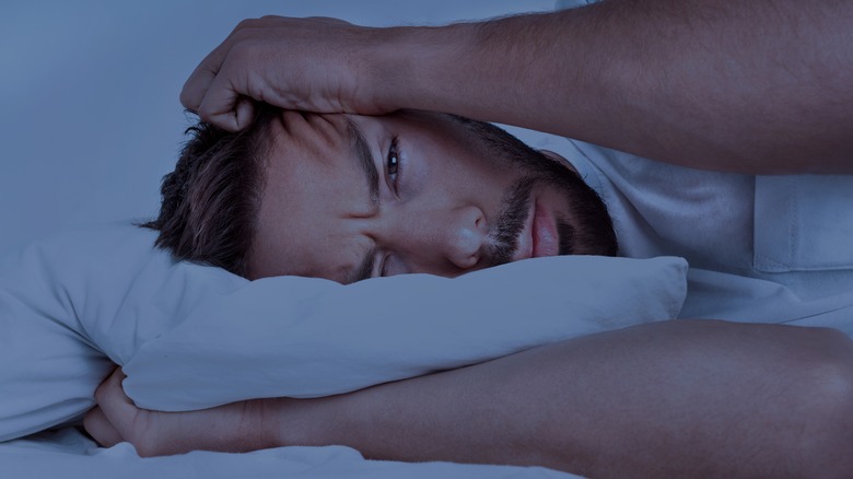 man lying in bed with insomnia