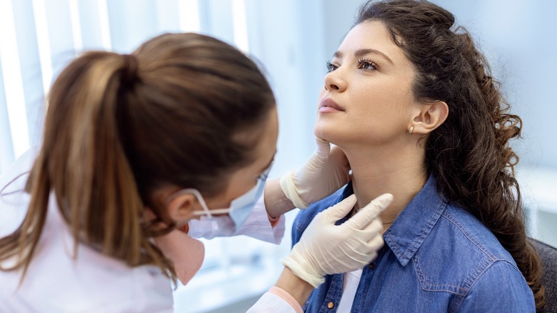 nurse examining thyroid gland