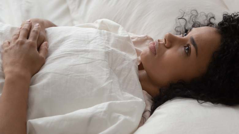 woman lying in bed with insomnia