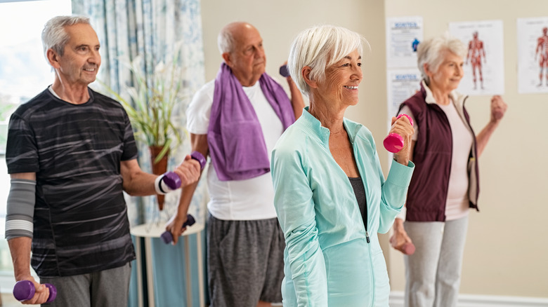 Group of elderly people lifting weights together.