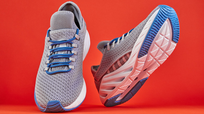 Pair of blue and white running shoes on red background