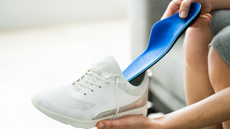 Woman putting orthotic into shoe