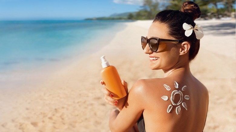 woman putting on sunscreen