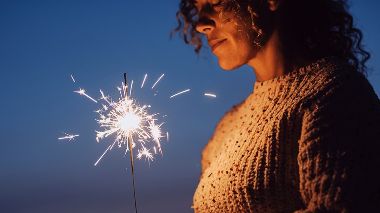 woman with eyes closed with sparkler 