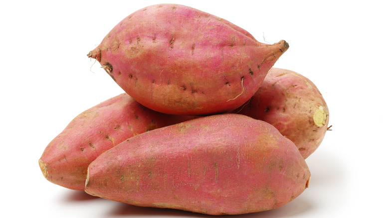 four sweet potatoes on white background
