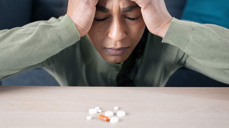 Stressed woman with multiple pills