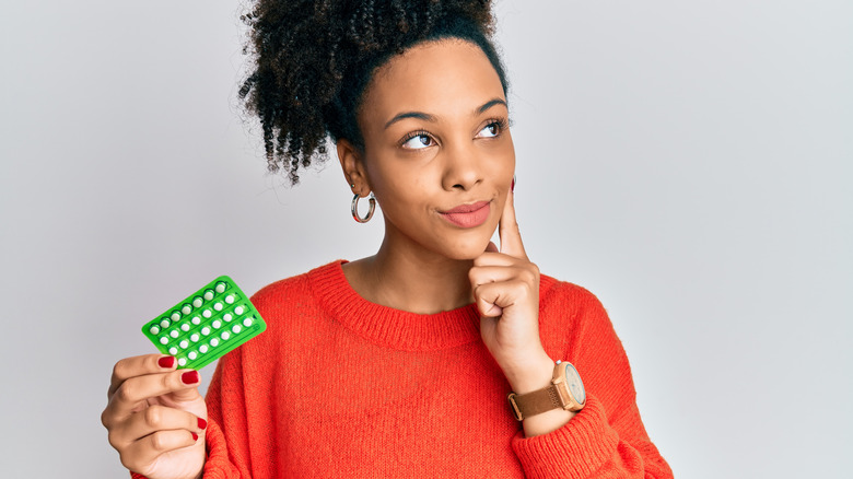 Woman holding birth control pills