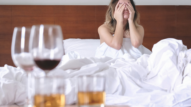 woman in bed with alcohol