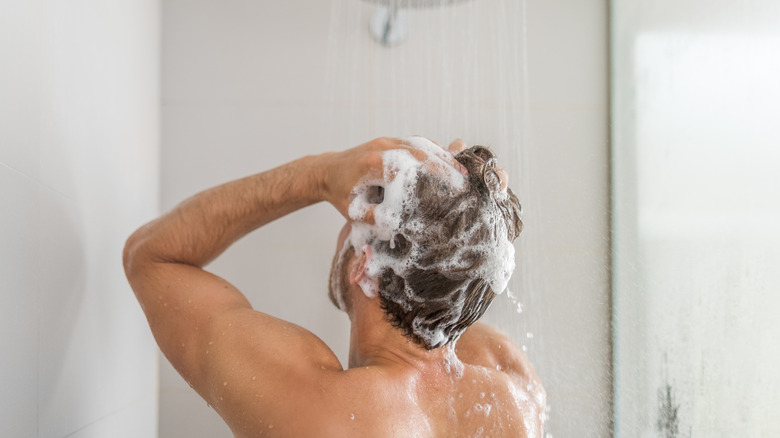 man having shower washing hair