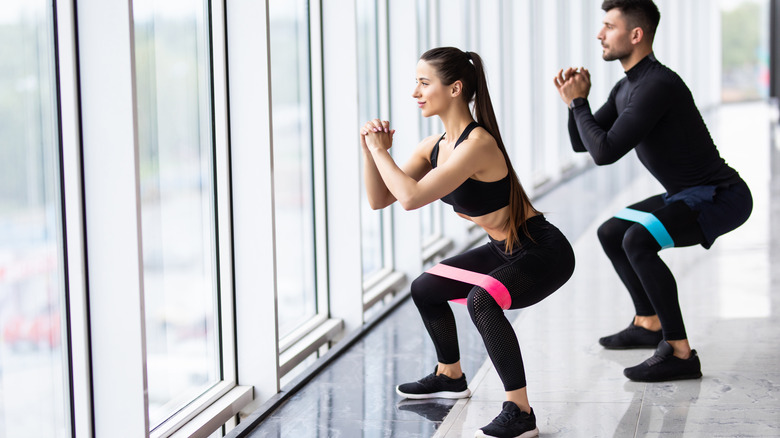 woman and man doing resistance training with bands