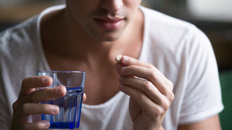Man taking a pill with water