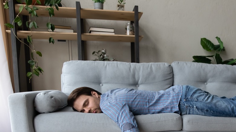 man laying on the couch looking depressed