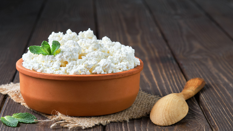 cottage cheese in bowl with mint and wood spoon