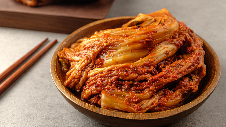 kimchi in wood bowl with chopsticks 