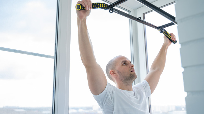 Man hanging from pull-up bar