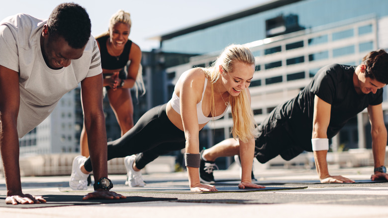 Group of exercisers performing push-ups 