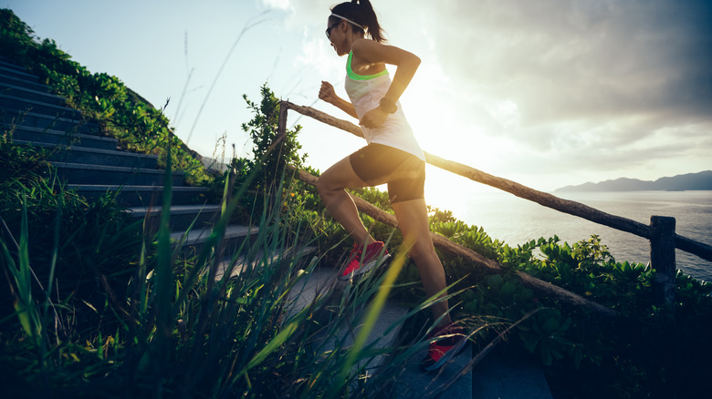 Woman running up a flight of stairs outdoors