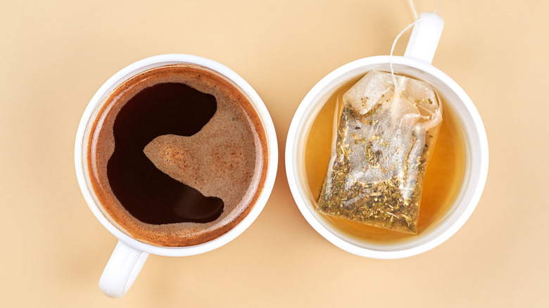 Two cups of coffee and tea on beige background