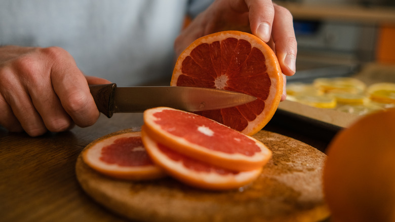 Man cutting a grapefruit into slices