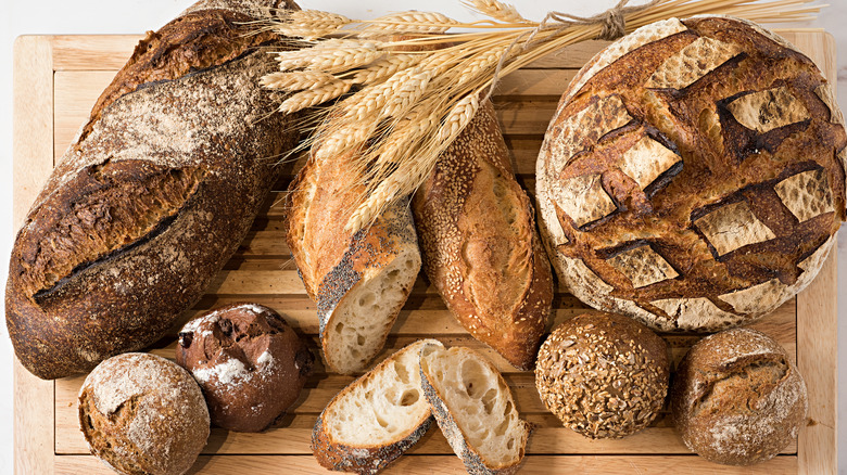 Variety of artisanal whole wheat breads on wooden cutting board