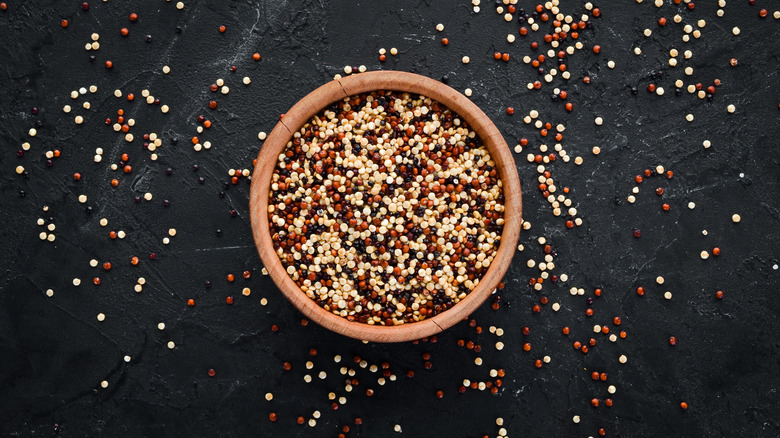 raw quinoa in bowl on black counter top