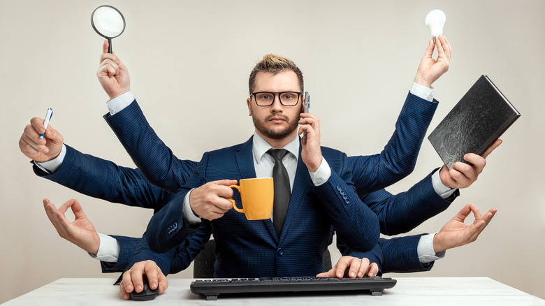 Multitasking businessman with multiple arms