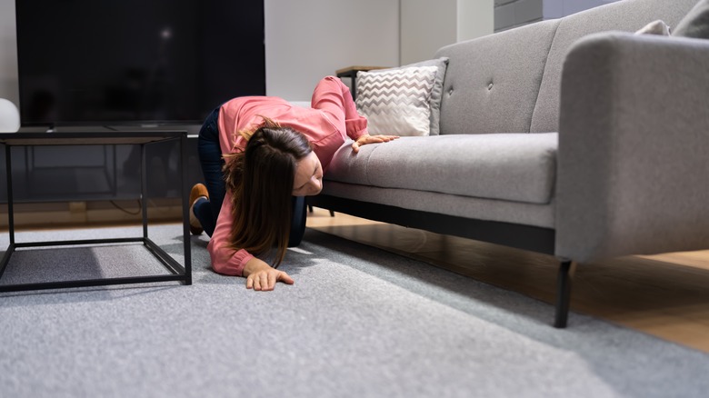 Woman looking under couch