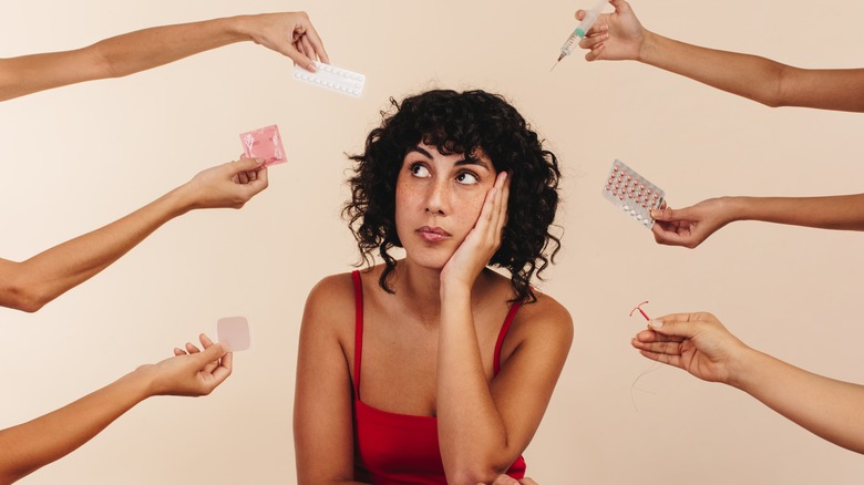 woman surrounded by birth control methods