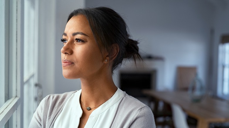 stressed woman looking outside window