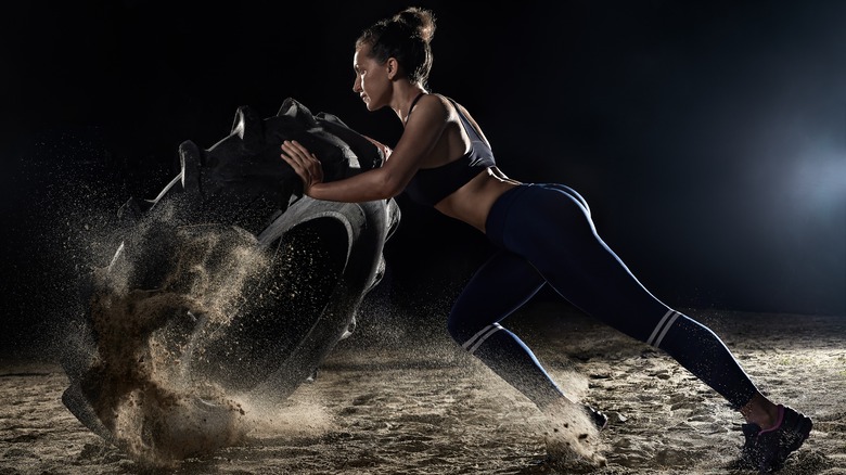 woman pushing tire over