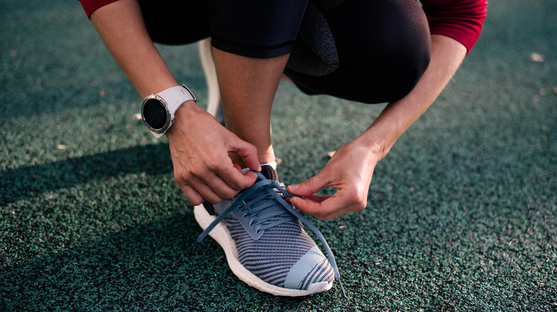 person lacing up shoes