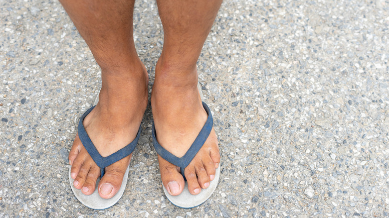 close up of male feet in flip flops