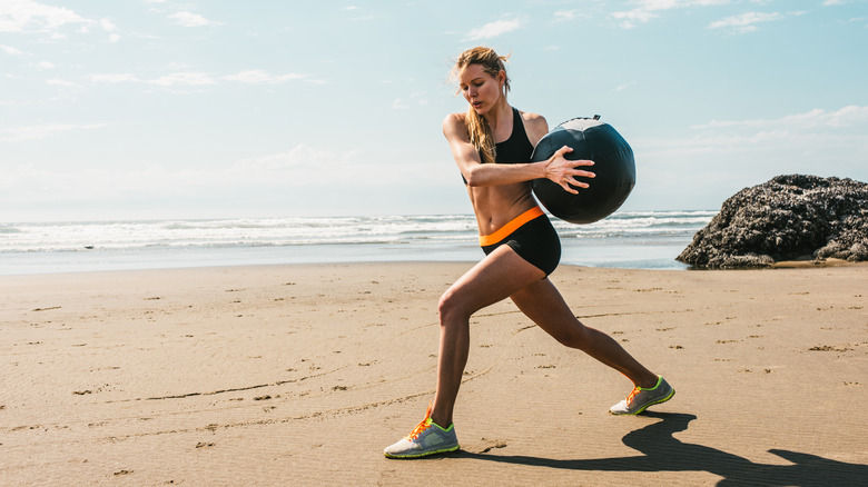 woman doing hiit workout on beach