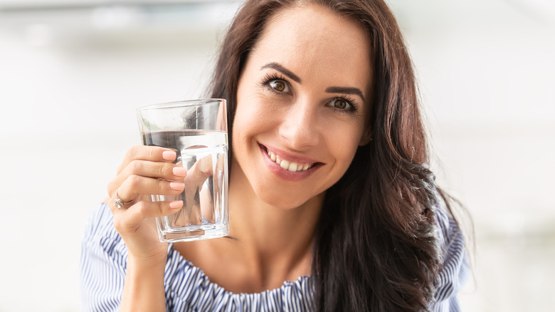 smiling woman holding a glass of water