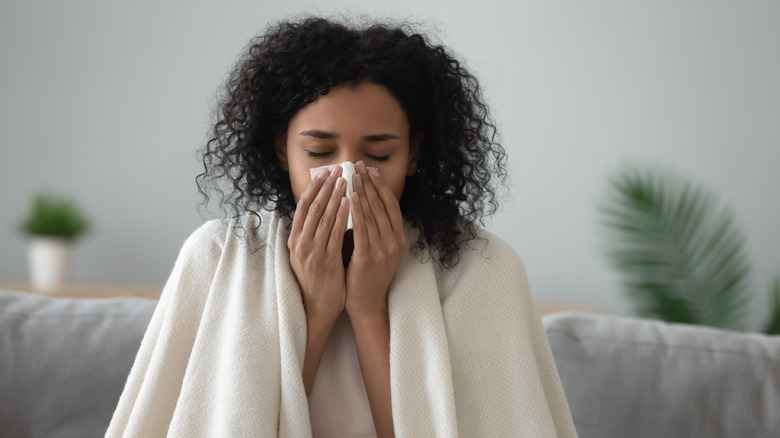 sick woman sitting on couch