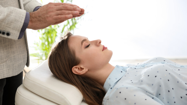 reclined woman with eyes closed in hypnosis session
