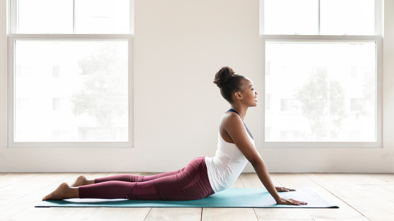 Woman doing cobra pose on a yoga mat