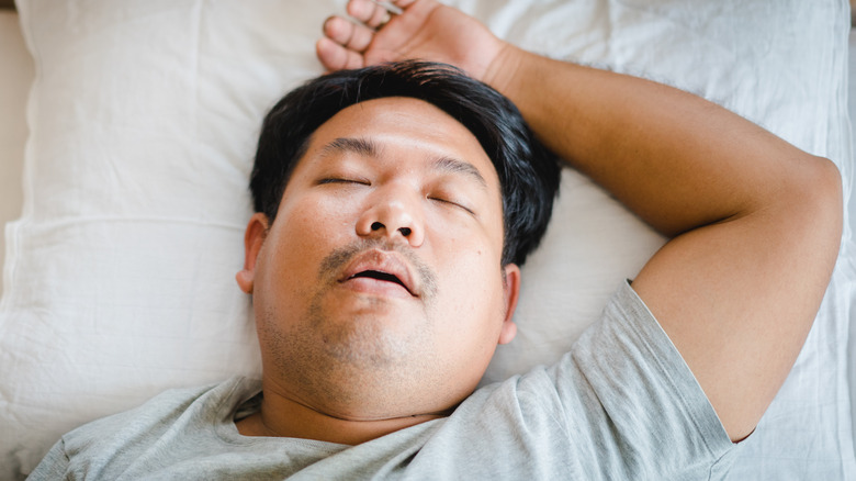 Man sleeping with one arm over head