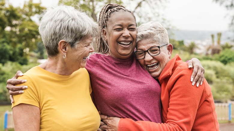 Three woman laugh and hug