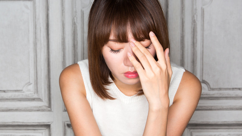 Woman crouching with hand on face