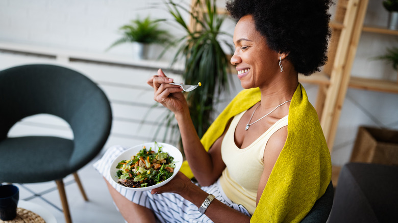 Woman sitting and eating a salad