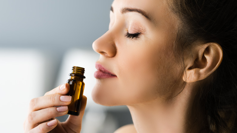 Woman smelling a bottle of essential oils