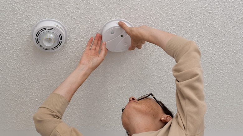 Woman changing battery on detector